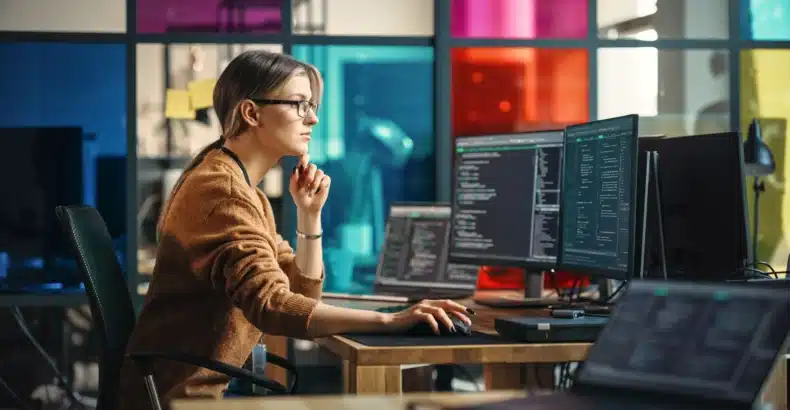 Girl focusing on coding and a desktop computer