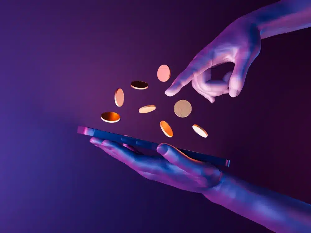Hands holding a phone with coins inbetween