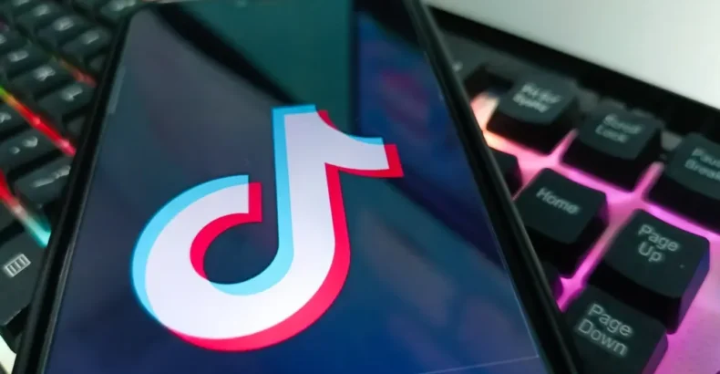 Mobile phone on top of a keyboard with a TikTok logo on the screen