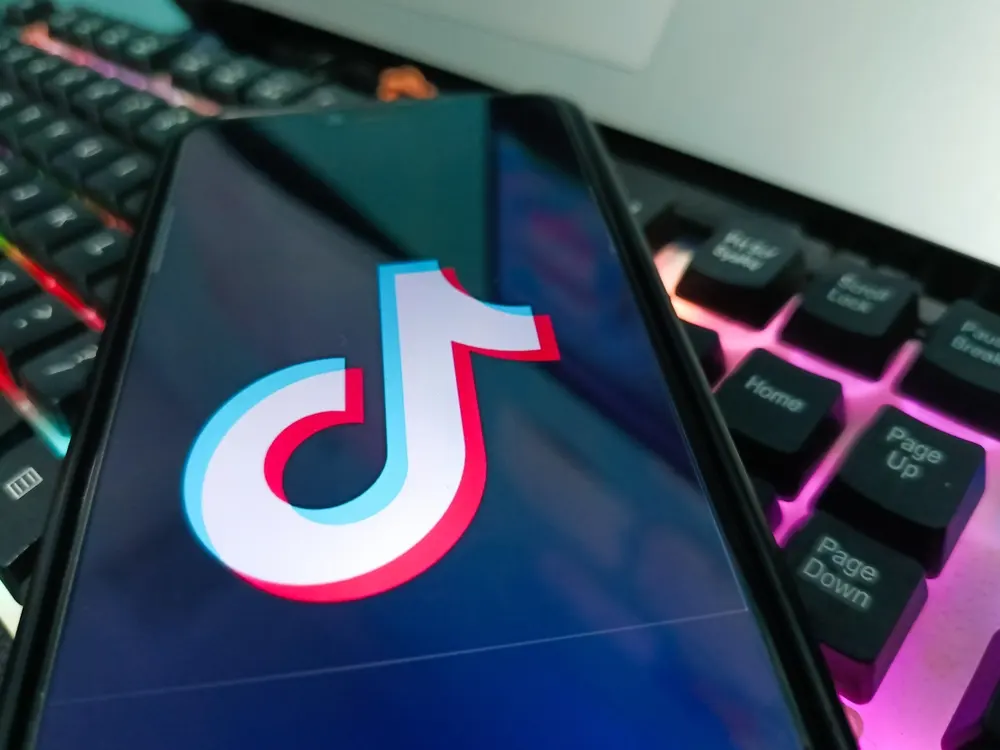 Mobile phone on top of a keyboard with a TikTok logo on the screen